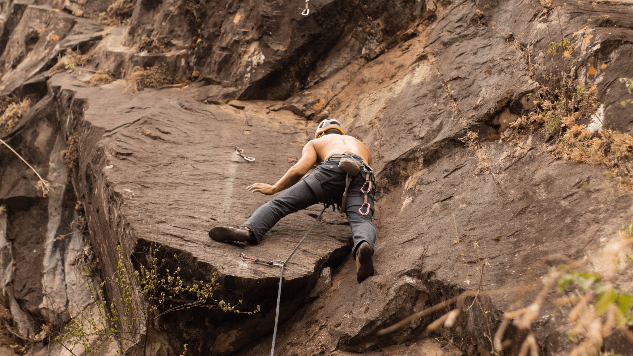 Man scaling a flat rock face in Lake Atitlan.