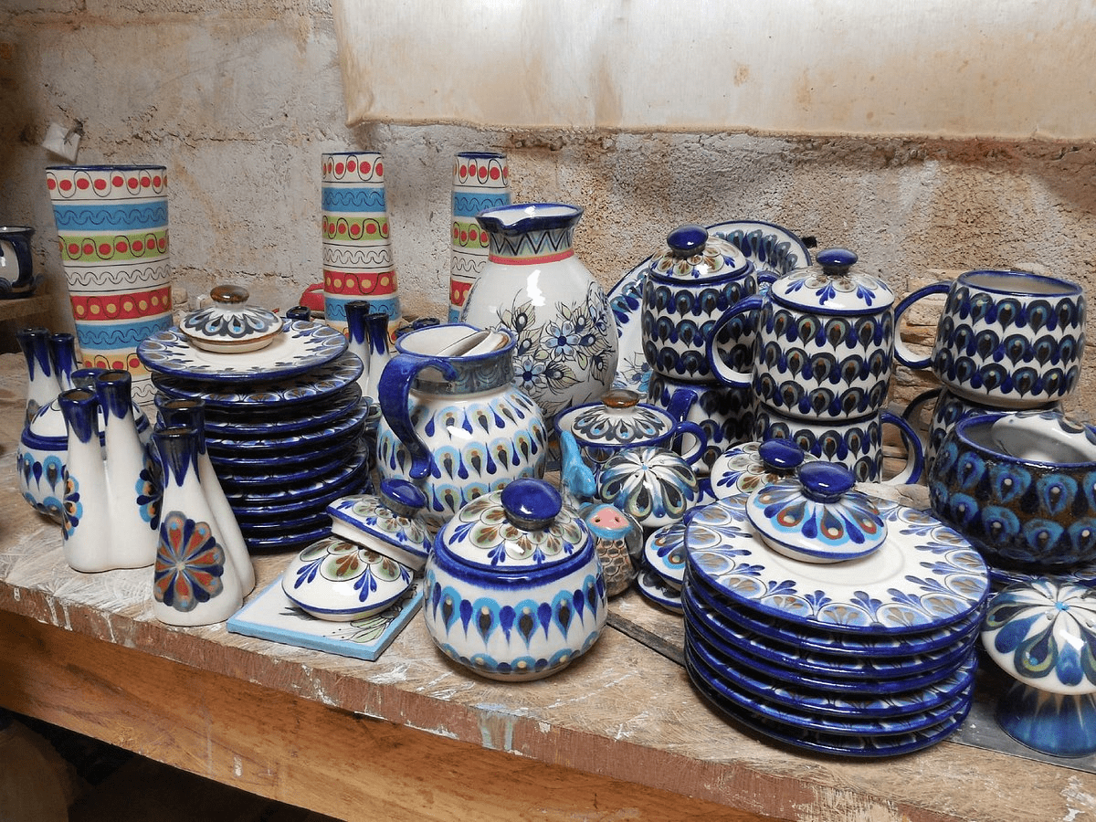 Green, blue and white hand painted plates, jugs and mugs.