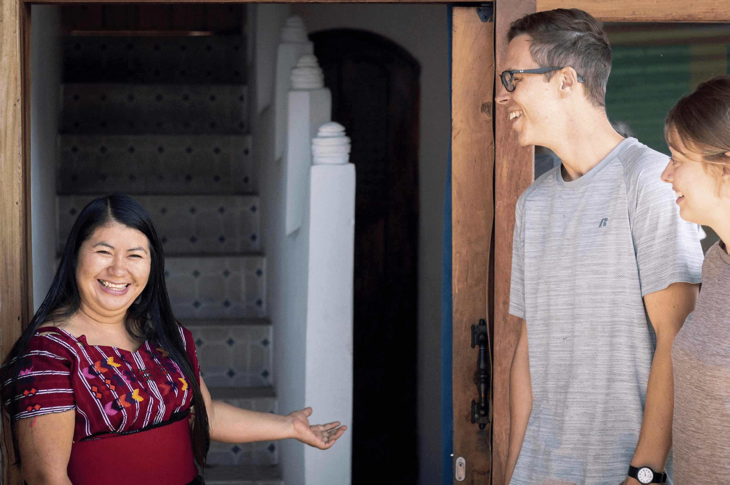 Mayan woman welcomes a couple into her home.