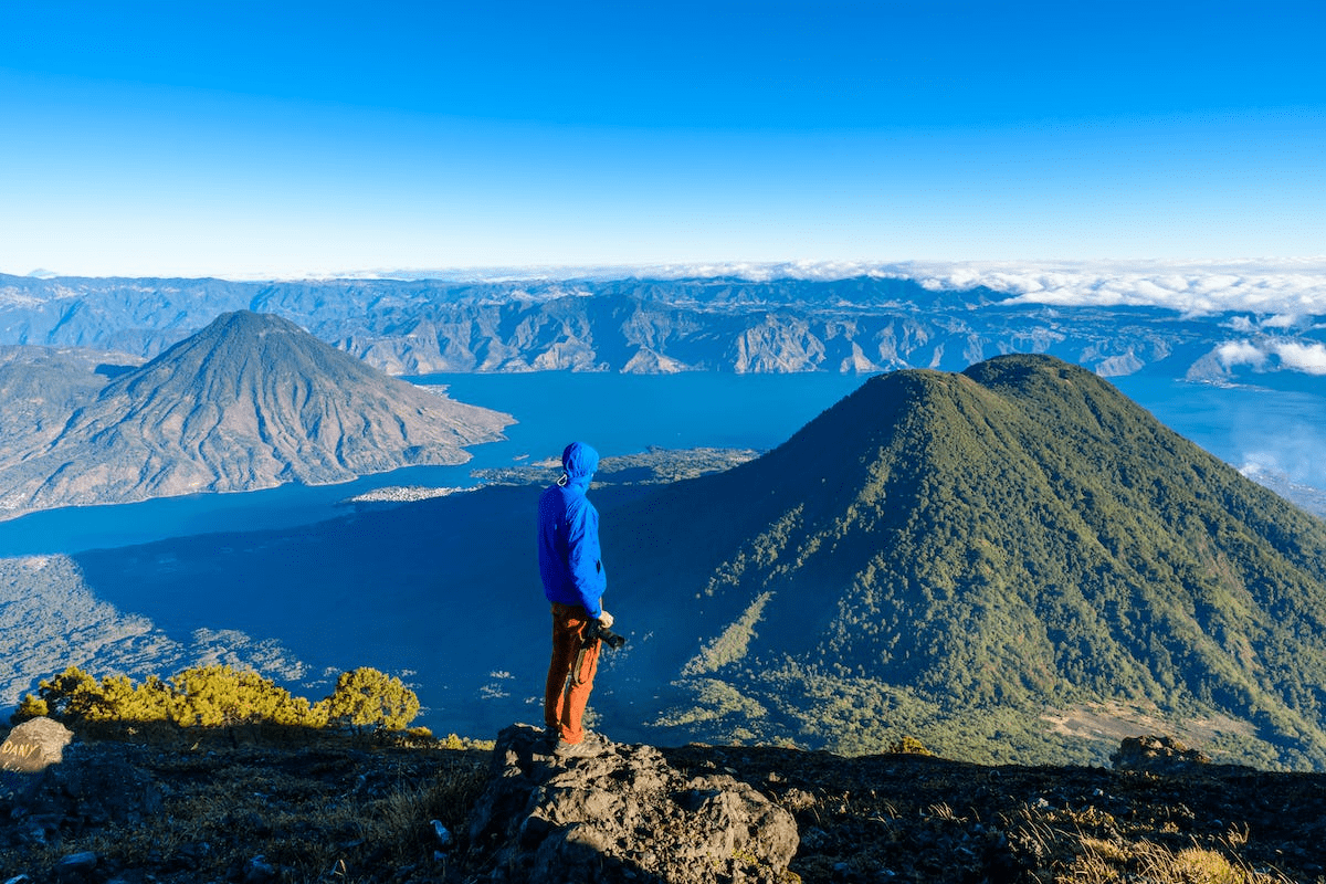 Man looks out to volcanoes feom the summit of Volcan San Pedro.