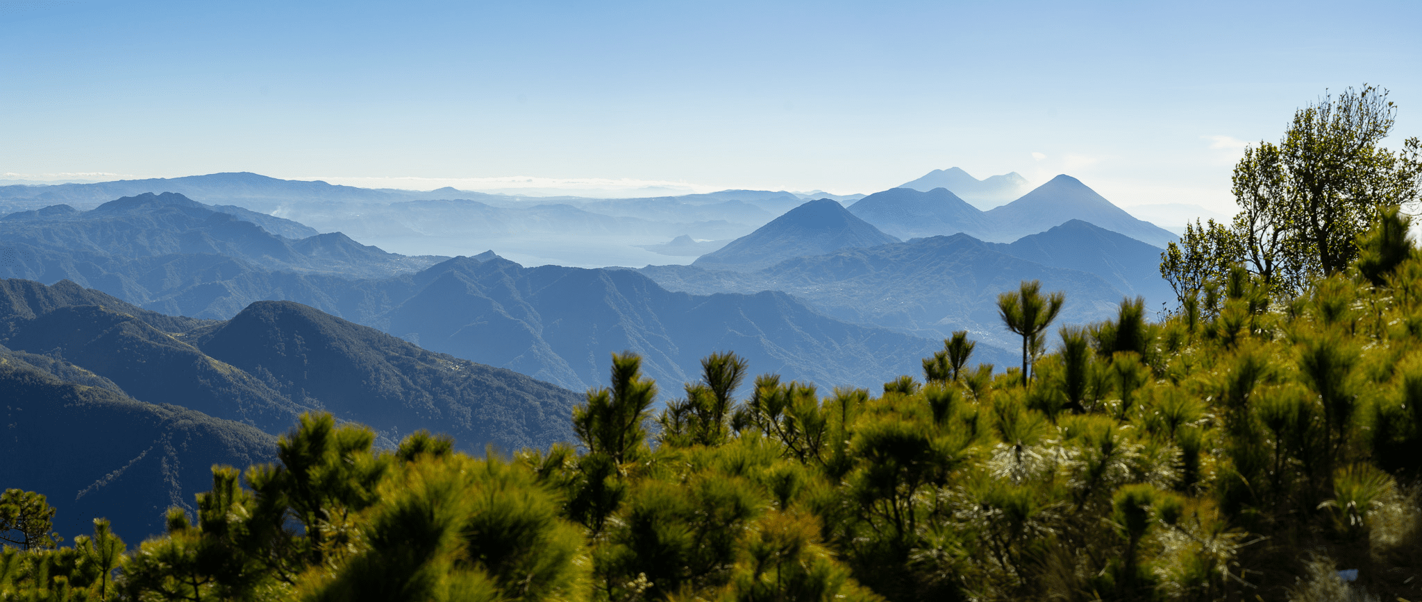 Landscape of mountains and lush greenery from the top of a mountain.